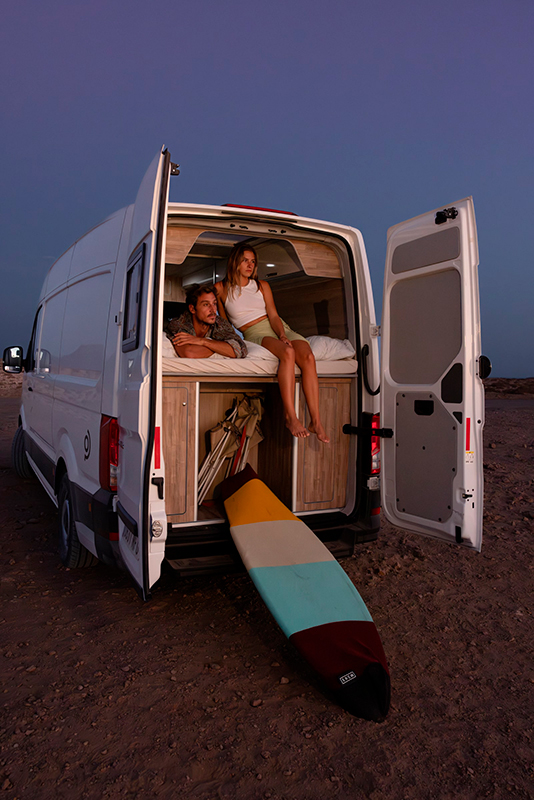Ein Paar ruht sich auf dem Bett eines Vanvaz-Wohnmobils während ihrer ersten Wohnmobilreise nach Fuerteventura aus.